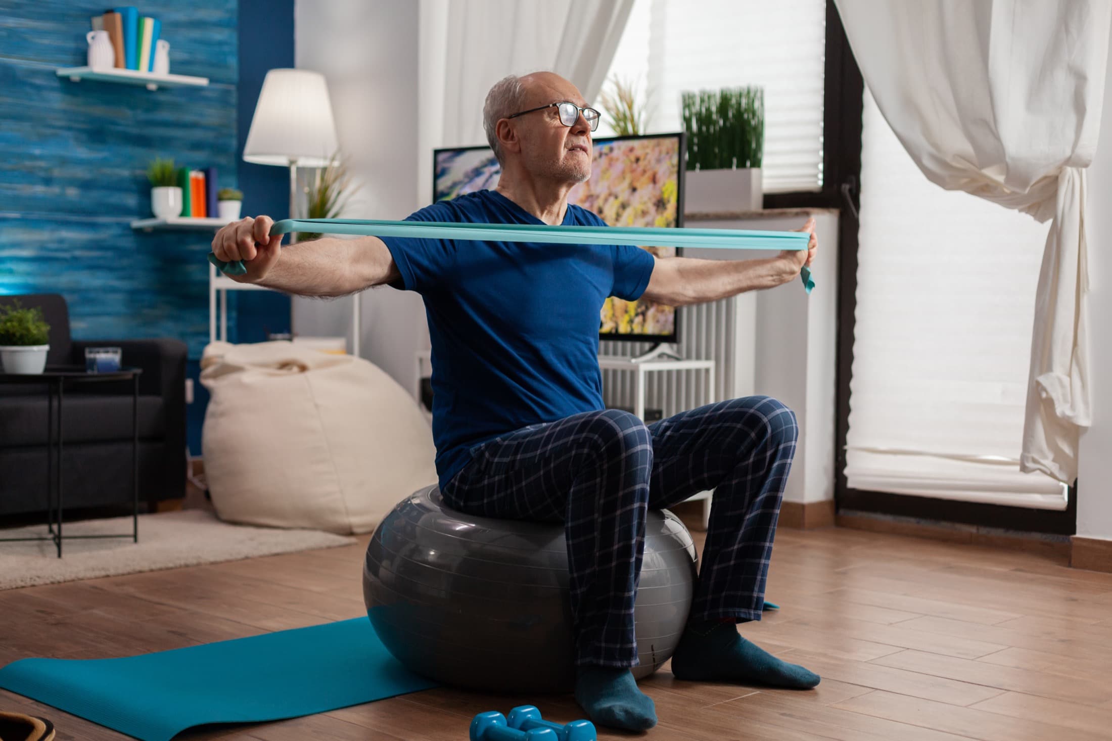 A gentleman exercising at home with a resistance band